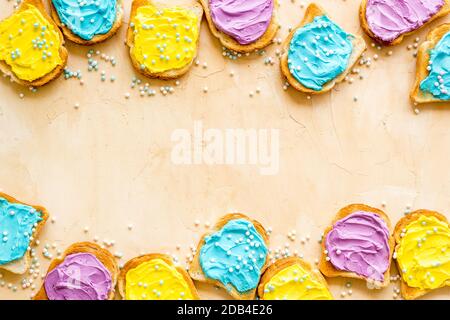 Divertente pane tostato con formaggio colorato spalmato. Vista dall'alto Foto Stock