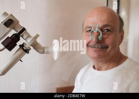 Uomo anziano che testa la funzione di respirazione mediante spirometria Foto Stock