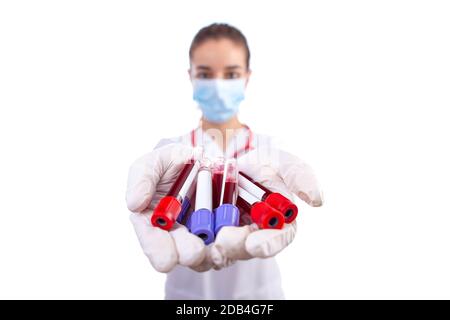 Donna assistente medica con tubo per analisi del sangue su sfondo bianco. Messa a fuoco selettiva Foto Stock