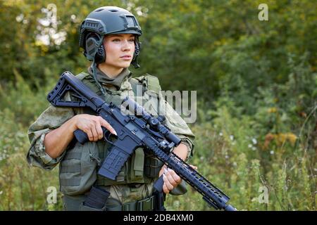 potente soldato sportivo pronto per la battaglia con armi, fucili o armi da combattimento. in natura selvaggia Foto Stock