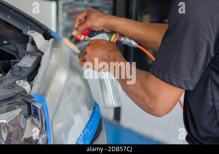 Mechanic la mano di lucidatura è la vettura del faro. Foto Stock