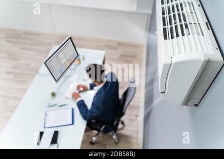 Uomo D'Affari Che Gode Il Raffreddamento Del Condizionatore D'Aria Nell'Ufficio Foto Stock