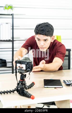 Giovani asiatici blogger maschio di impostazione della telecamera per la registrazione live di vlog video tutorial session a casa. Esso blogging o vlogging, social media broadca hobby Foto Stock