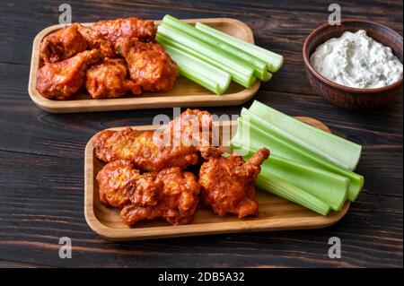 Due porzioni di ali di bufalo con gambi di sedano fresco e salsa di formaggio blu Foto Stock