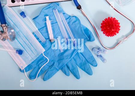Diversi oggetti da laboratorio, tra cui maschera protettiva, guanti, rack per fiale, provette e altro. Foto Stock