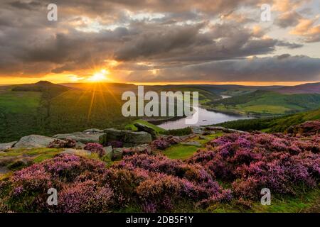 Il sole serale esplodere attraverso le spettacolari nuvole con una vista epica del lago artificiale di Ladybower nel Peak District. Foto Stock