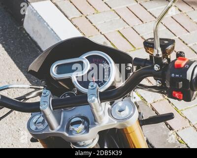 Frammento di volante di una motocicletta con tachimetro rotondo all'esterno. Foto di primo piano con filtro Foto Stock