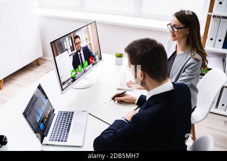Due giovani imprenditori di conferenze video sul computer in ufficio Foto Stock