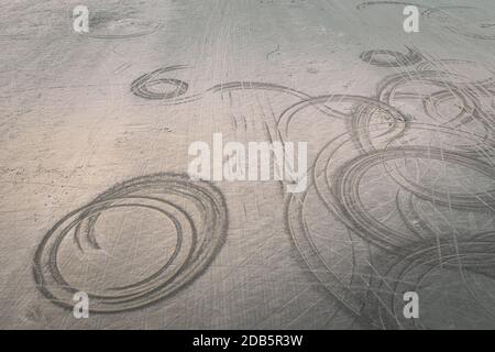 Segni di rotazione della ruota dell'automobile sulla spiaggia di Black Rock Sands nel Galles del Nord. Drone aereo sparare Foto Stock