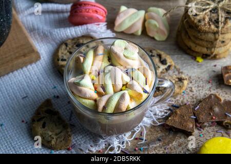 Il cacao con marshmallows e forno al cioccolato, i muffin e le fette di cioccolato si trovano su un tavolo di legno. Foto Stock