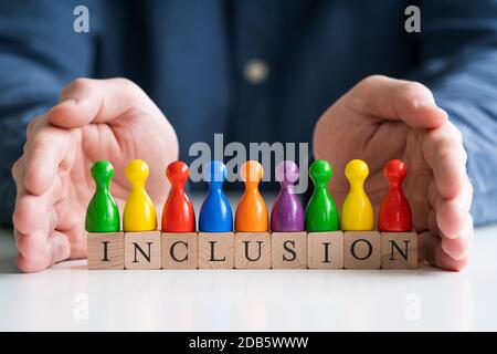 Uomo che protegge testo di inclusione e pedine multicolore Foto Stock