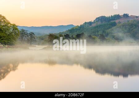 Misty primavera mattina a Rydal Water nel Distretto dei Laghi Inglese con calmi riflessi in acqua. Foto Stock