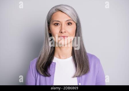 Foto ritratto di una vecchia signora calma con bianco lungo capelli che indossano cardigan viola isolato su sfondo grigio Foto Stock