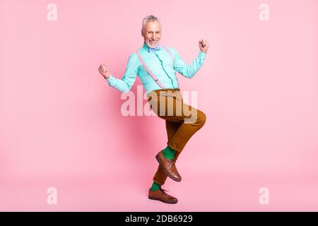 Lunghezza intera corpo dimensioni profilo laterale foto di felice vecchio uomo sorridente gesturing come vincitore isolato su sfondo di colore rosa Foto Stock