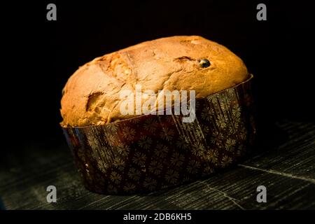 Il tipico dolce panettone natalizio italiano su sfondo di legno nero Foto Stock