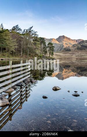 Riflessi di montagne in acqua a Blea Tarn in una chiara mattina di primavera. Lake District, Regno Unito. Foto Stock