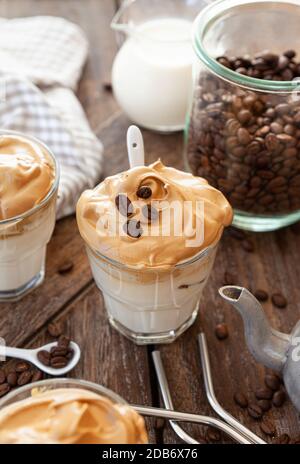 Caffè montato in un bicchiere con chicchi di caffè Foto Stock