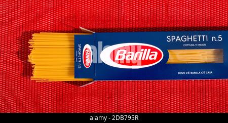 Pacchetto aperto di Barilla Spaghetti pasta in confezione al dettaglio visto in alto su uno sfondo tessile rosso Foto Stock