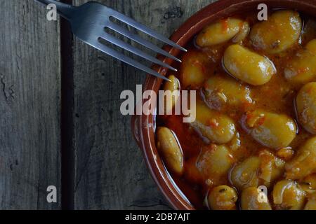 Fagioli giganti cotti al forno e forchetta su tavola di legno Foto Stock