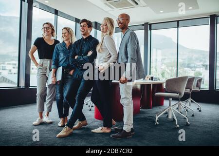 Team aziendale multietnico insieme nella sala riunioni dell'ufficio. Gruppo di colleghi dopo una riunione in carica. Foto Stock