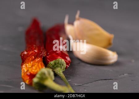 Peperoncini rossi caldi e aglio, isolati su nero. Foto Stock