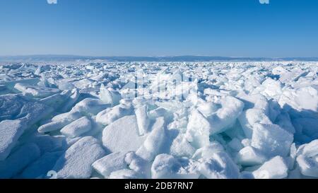 Paesaggio invernale del ghiacciato Lago Baikal. Campi di gobba di ghiaccio con mucchi di grandi blocchi di ghiaccio. Natura sfondo. Foto Stock