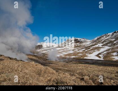 Il vapore che sale da fonti geotermiche in Islanda vicino a Reykjadalur Foto Stock