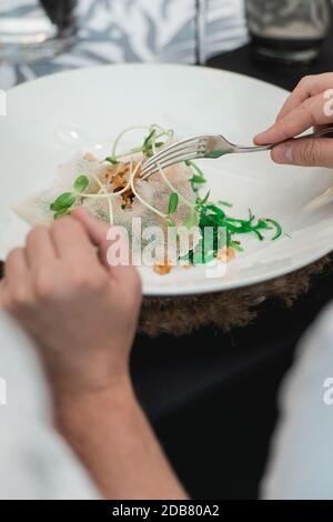 Donna che mangia insalata di Calamari croccante con lattuga, limone e asparagi Foto Stock