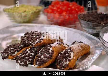 Cannoli siciliani con ricotta e ingredienti sullo sfondo Foto Stock