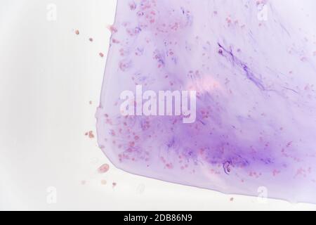 Le macchie blu del colorante nella vasca bianca si sciogliono in acqua. Foto Stock
