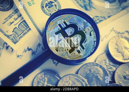 Bitcoin sotto lente di ingrandimento su sfondo di dollari. Il concetto di sostituire la moneta reale virtuale e la crescita della quota di cripto curr Foto Stock
