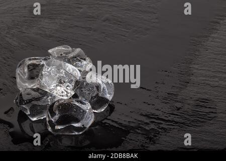 Cubetti di ghiaccio sul bagnato nero ardesia board Foto Stock
