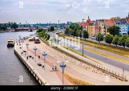 Piastowski Boulevard sull'argine del fiume Odra con navi convertite in ristoranti. Persone a piedi e rilassarsi sulla riva del fiume nel centro storico Quey Foto Stock