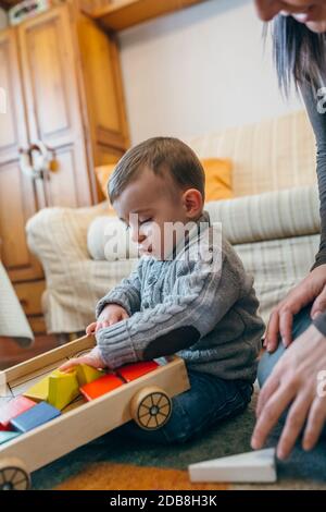 Il bambino gioca con una costruzione di gioco in legno Foto Stock