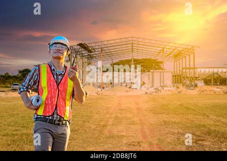 Lavoratore di costruzione in piedi di fronte al cantiere, Thailandia Foto Stock