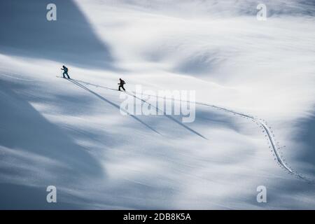 Due persone sciano nelle Alpi, Lienz, Austria Foto Stock