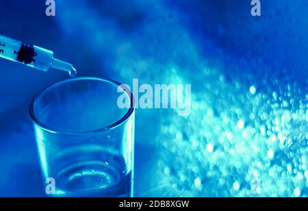 un ricercatore svuota il liquido da una fiala in un contenitore di vetro per trovare un vaccino contro il virus in un laboratorio di analisi scientifica e di ricerca. Scienza A. Foto Stock