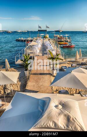 CANNES, FRANCIA - AGOSTO 15: Messa a punto dei tavoli e delle sbarre sulla spiaggia del Majestic Barrière hotel a Cannes, Costa Azzurra, Francia, come visto su A. Foto Stock