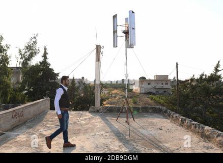 Sweida, Siria. 16 Nov 2020. Diaa Abdullah, un ingegnere di 31 anni, si trova vicino a una turbina eolica sul tetto della sua casa nella provincia di Sweida, Siria meridionale, il 2 novembre 2020. Credit: Ammar Safarjalani/Xinhua/Alamy Live News Foto Stock