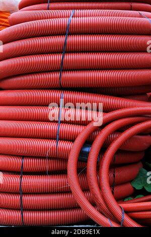 Grande pila di rosso cavi di plastica in bobine Foto Stock