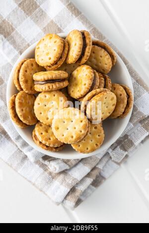 Mini biscotti panna sandwich in ciotola su tavolo bianco. Vista dall'alto. Foto Stock
