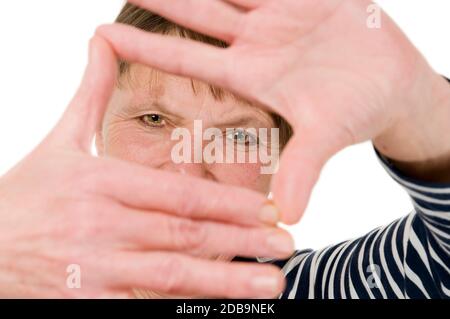 Vista frontale della testa e della spalla di una donna matura che tiene un casco per mano verso la telecamera su sfondo bianco. Foto Stock