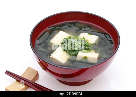 Cibo giapponese, zuppa di tofu di miso e wakame alle alghe in una ciotola con bastoncini Foto Stock