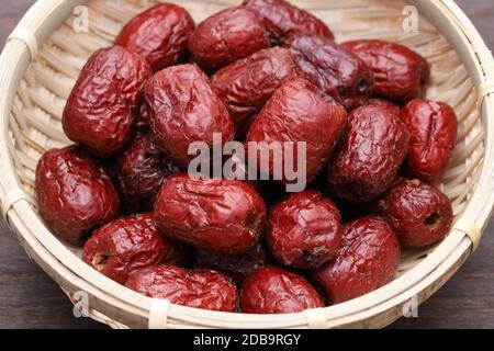 Jujube essiccato, frutta secca cinese dattero rosso in un cesto di bambù Foto Stock