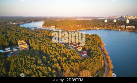 Zona ricreativa e vista aerea della grande città. Riva del fiume con foresta e sanatorium in primavera luce del sole. Serata di aprile al lago vicino Minsk, Bielorussia. Beau Foto Stock