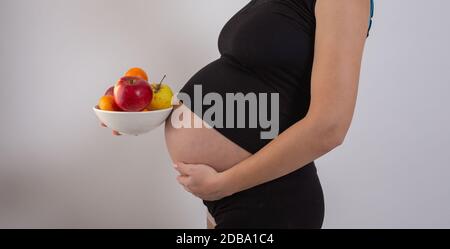 Gravidanza e sana alimentazione biologica. La donna incinta conserva frutta fresca di vitamina, spazio libero. Inserire il testo. Concetto di aspettativa e di salute Foto Stock