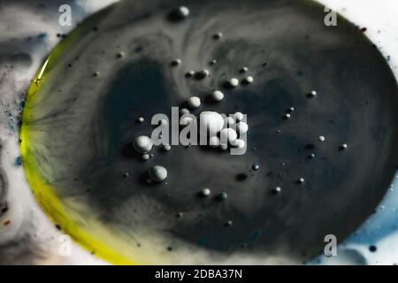 Estrazione del colore dell'olio in acqua. Un primo piano di un oggetto rotondo. Foto macro. Foto Stock