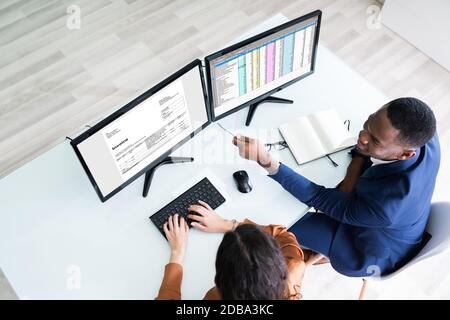 Maschio e femmina conti lavora su computer con fattura al posto di lavoro Foto Stock