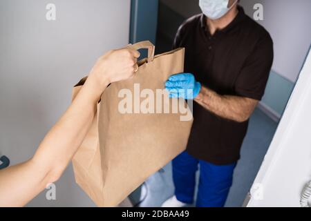 Corriere che consegna cibo e pasto a Donna a casa da Ristorante Foto Stock