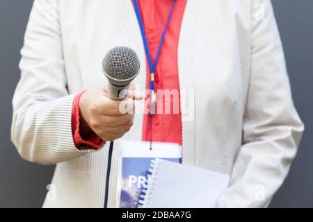 Reporter tenendo il microfono e facendo premere intervista Foto Stock